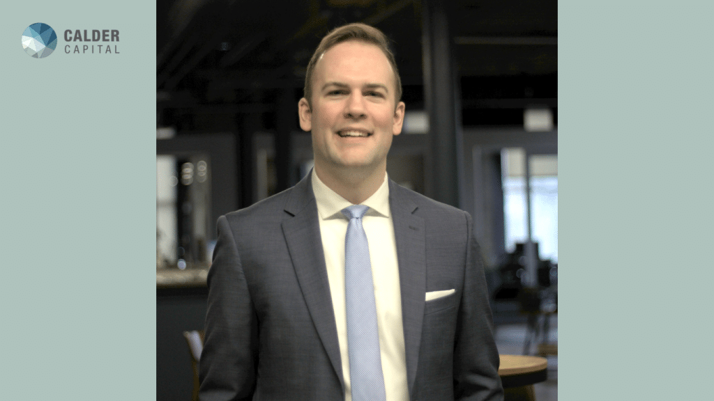 Brandon Sinclair, Calder Capital’s new Marketing & Public Relations Associate, smiling in a professional headshot. He is wearing a light blue suit and a white shirt in an office background.