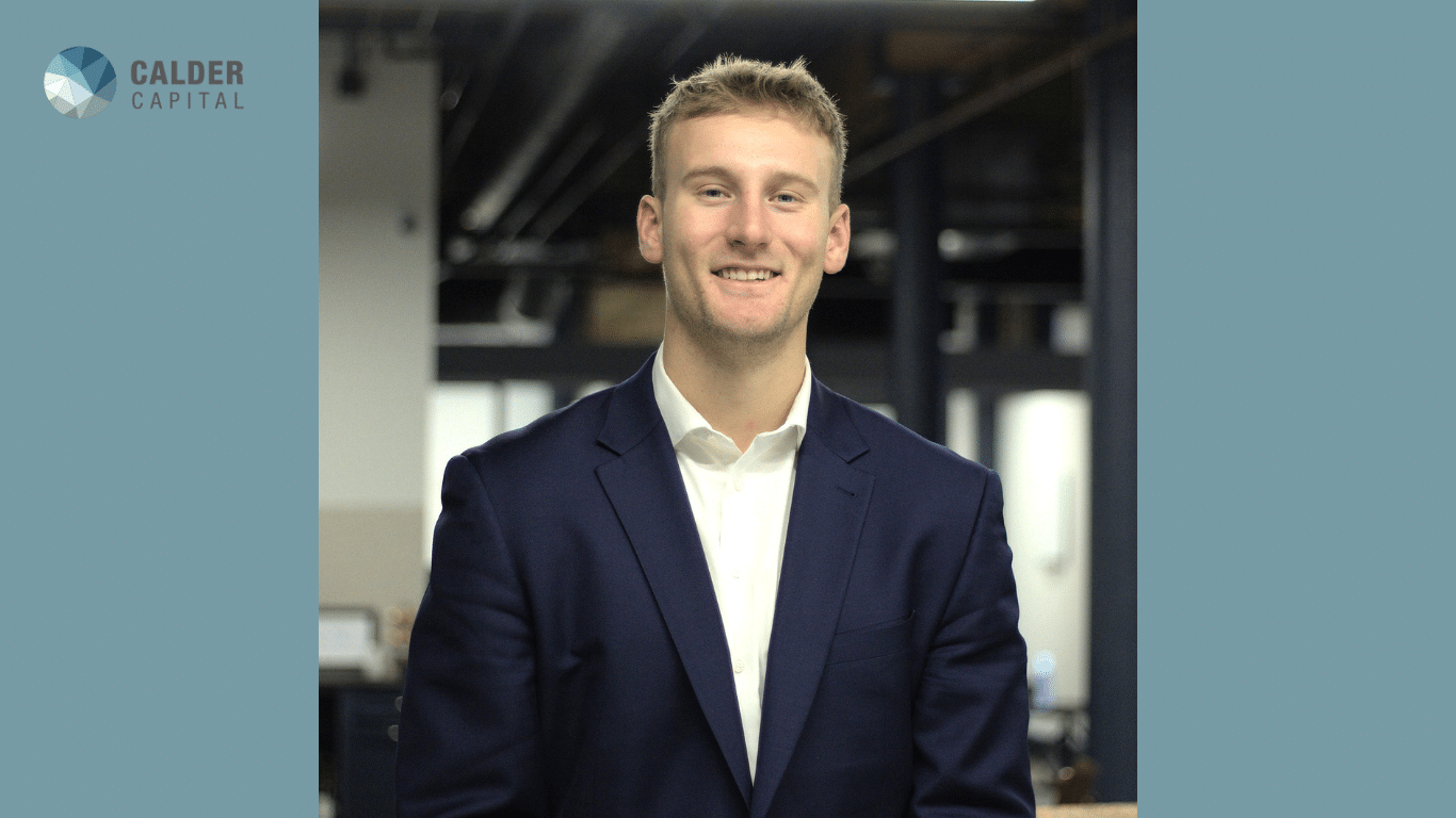 Cade Peterson, Calder Capital’s Buy-Side Associate, smiling in a professional headshot. He is wearing a navy suit and white shirt in an office background.